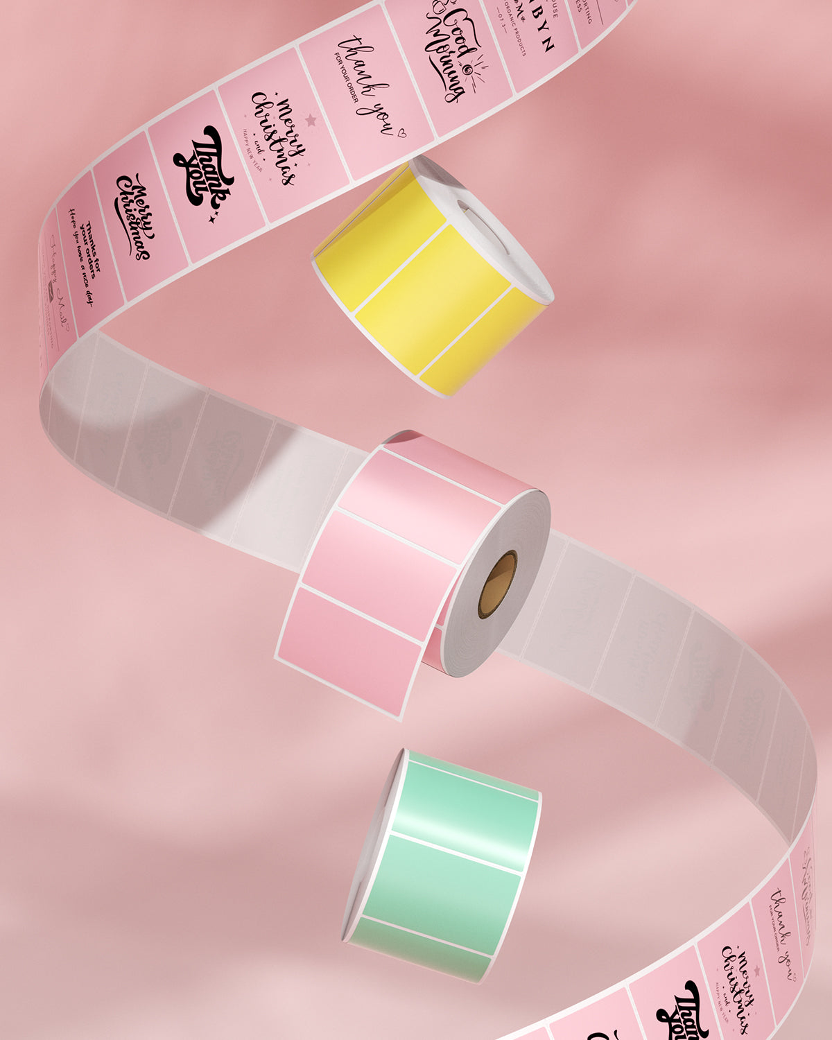 Colorful thermal label rolls in pink, yellow, and green on a pink background, ideal for printing.
