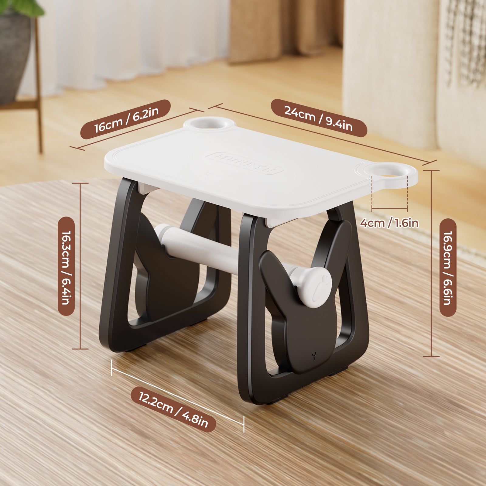 Compact black and white folding step stool with measurements on a wooden table in a modern room