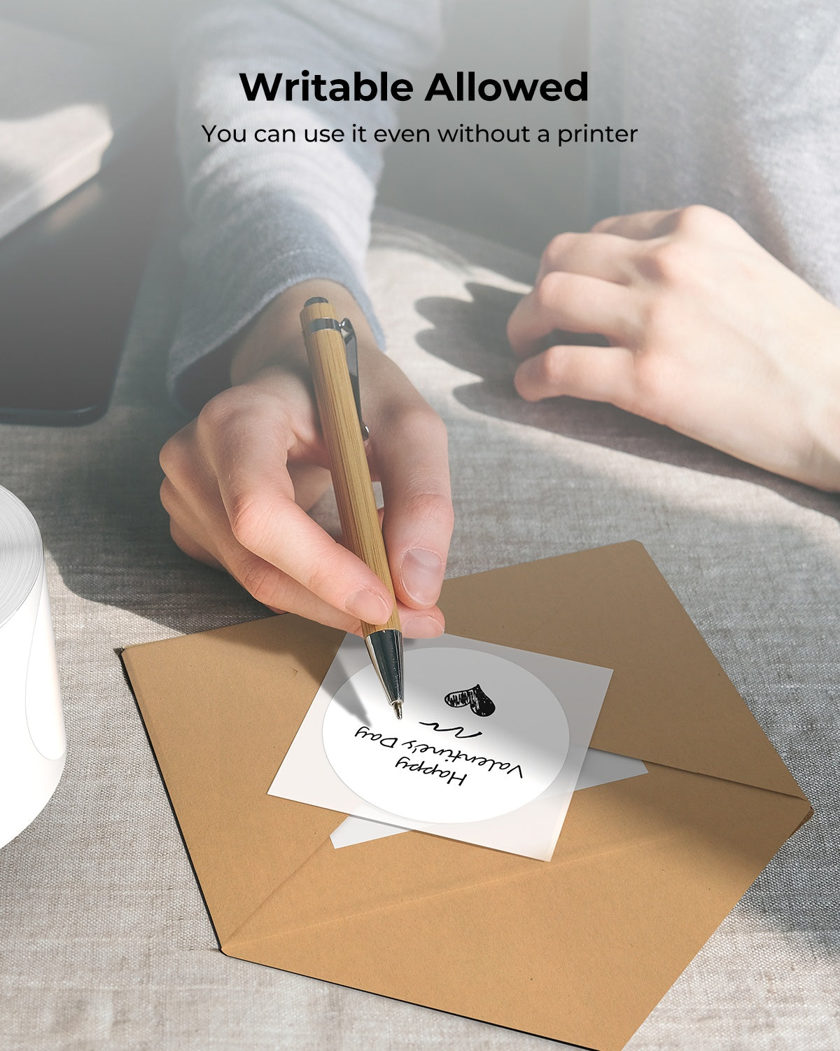 Person writing on writable white label sticker placed on envelope for Valentine's message