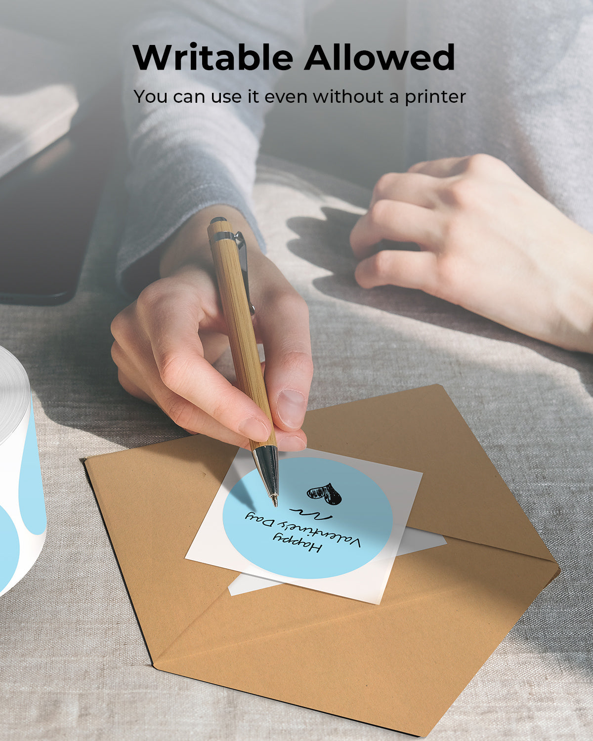 Person writing on a blue 2x2 inch round thermal label sticker for envelopes.