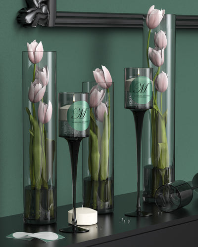 Pink tulips and a green label candle in tall glass vases on a modern black mantel