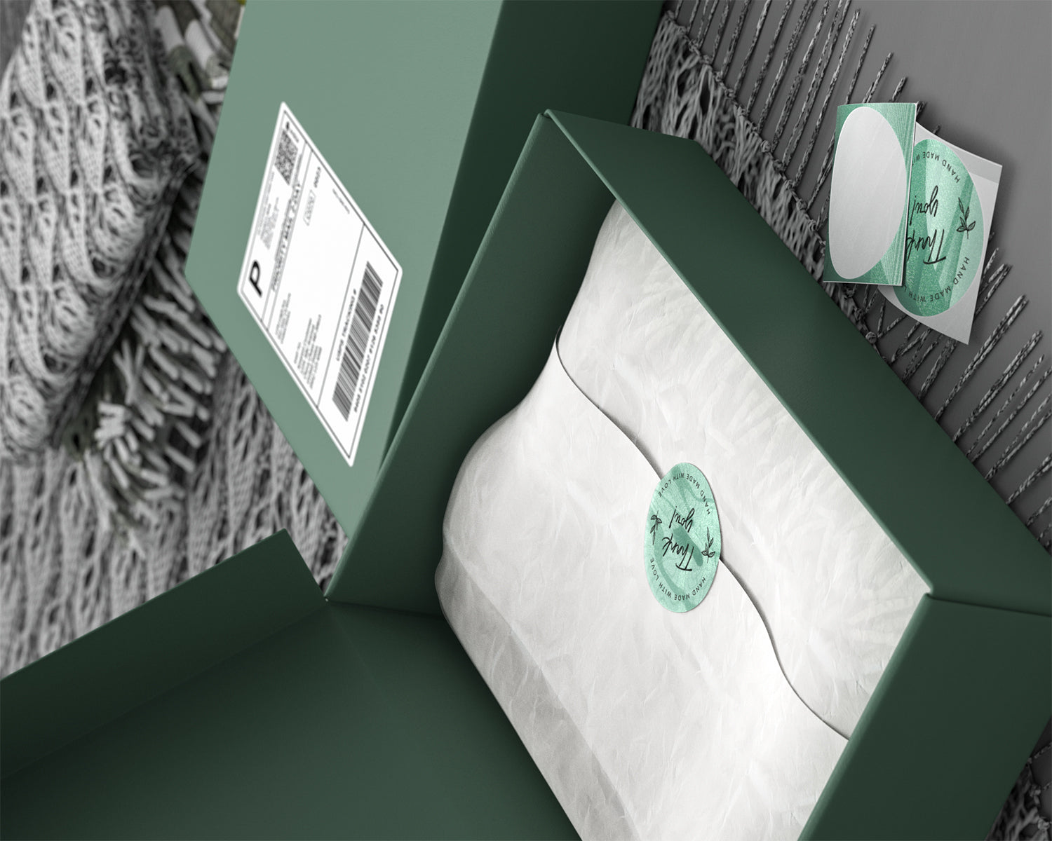 Green shipping box with shipping label and thank you sticker sealing white tissue paper, packaging supplies