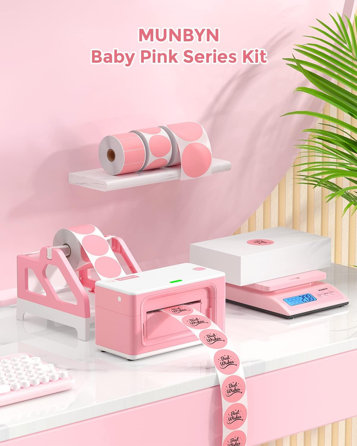 Pink thermal label printer kit with printed stickers, label rolls, and digital scale on a desk.