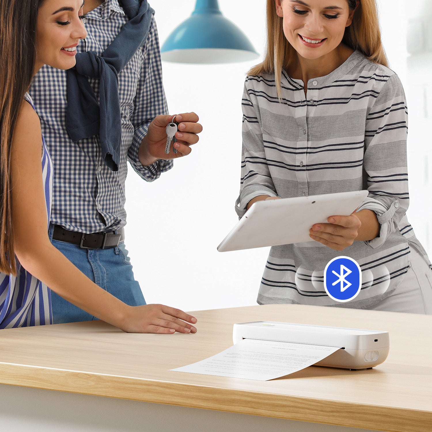 People using a wireless Bluetooth thermal printer to print documents from a tablet on a desk