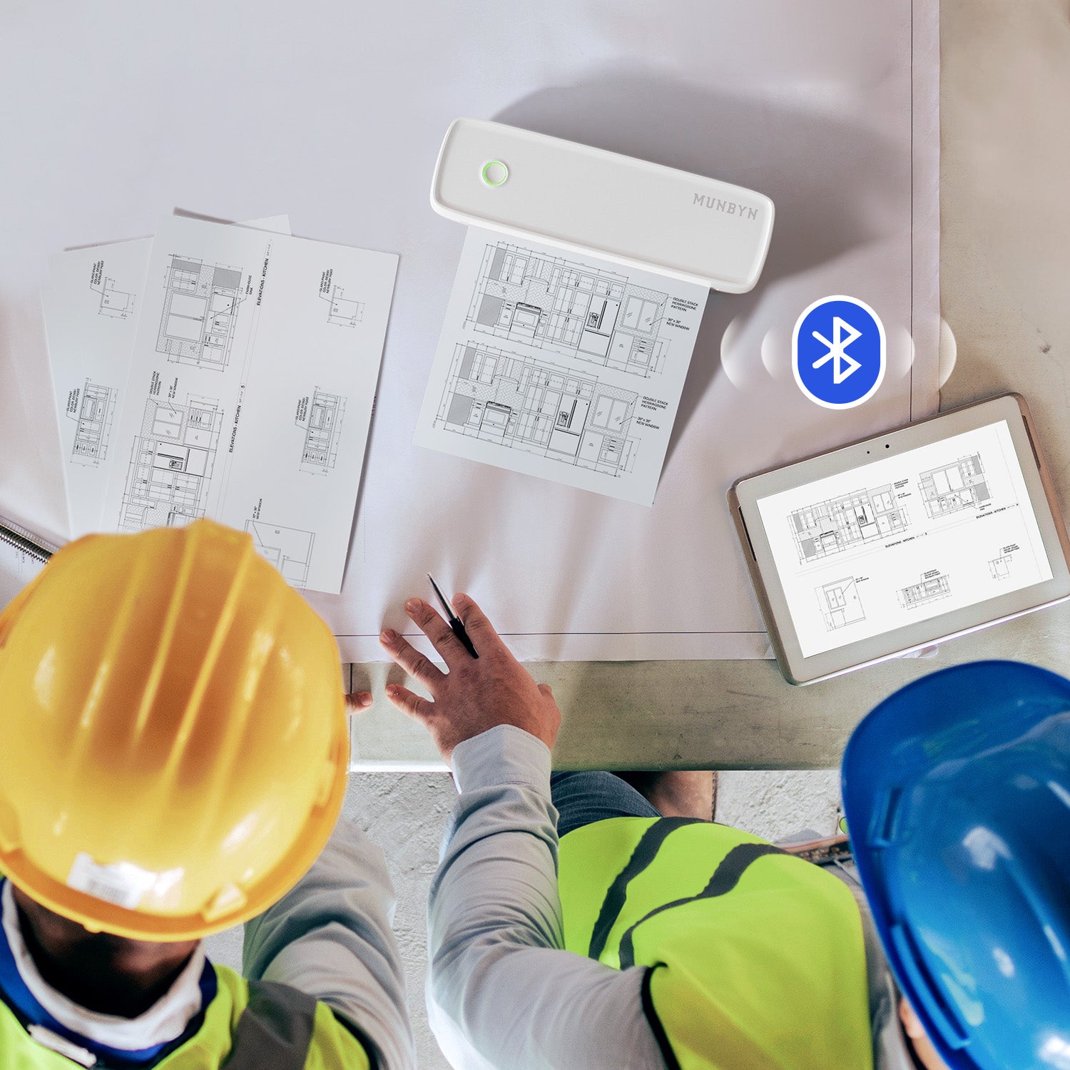 Engineers using portable wireless thermal printer for printing building plans at worksite