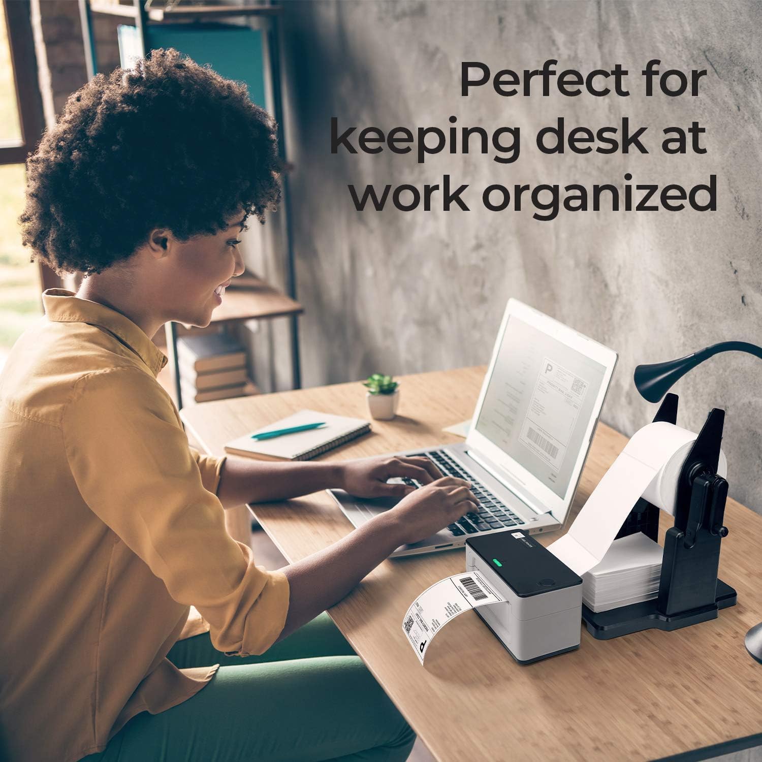 Woman using a thermal label printer and laptop at a tidy office desk, printing shipping labels