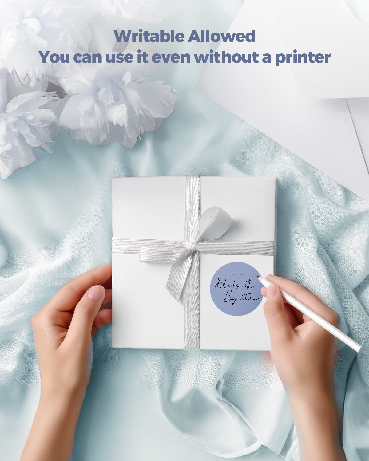 Person writing on a round blue writable label sticker on a white gift box with ribbon